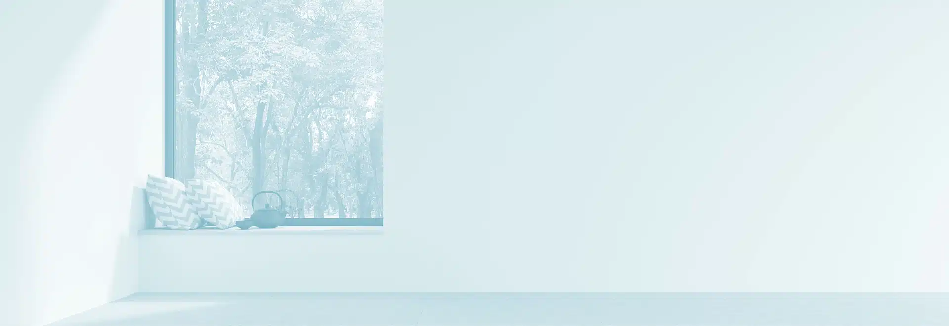 A window ledge with two stripey cushions and a teapot on it, there are many trees outside.