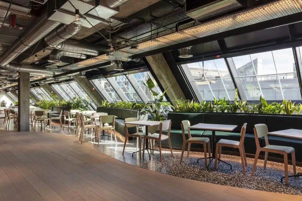 Oscar Acoustics' SonaSpray K-13 grey applied to the ceiling of a communal space in a modern office building.