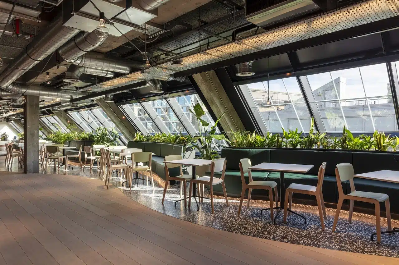 Oscar Acoustics' SonaSpray K-13 grey applied to the ceiling of a communal space in a modern office building.