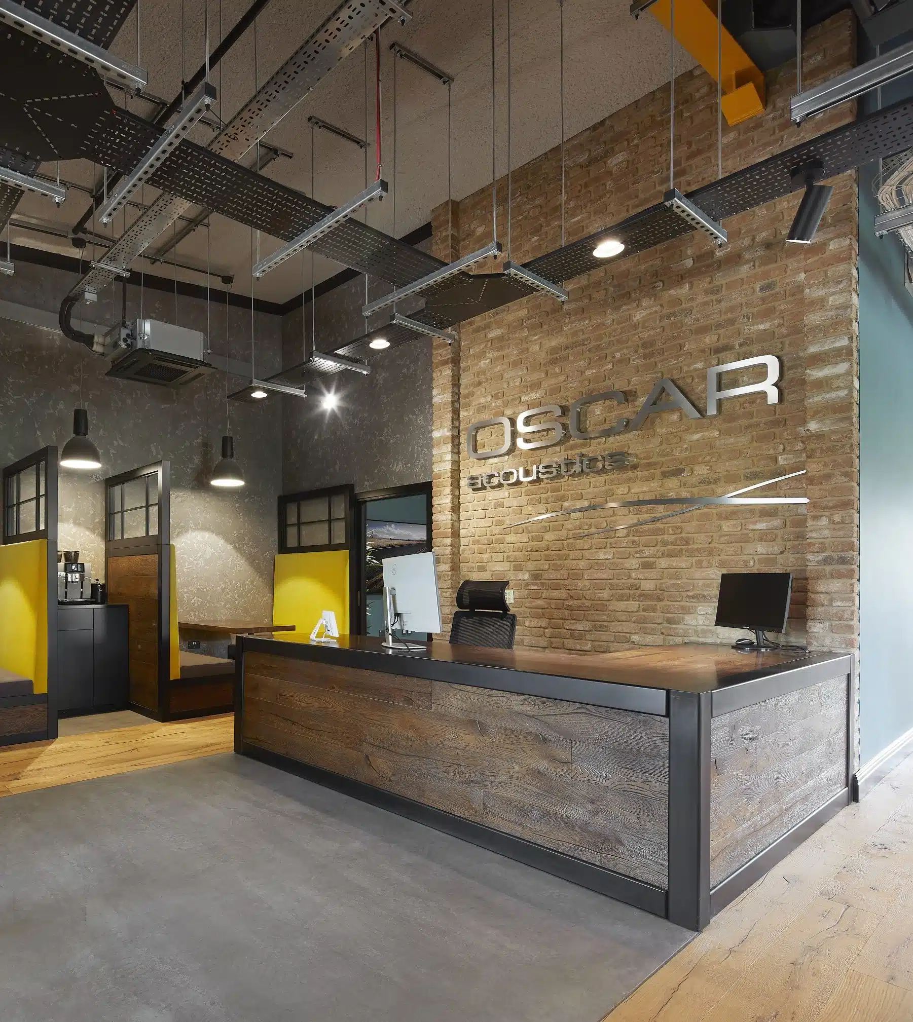 office reception with desk, booths and brick walls