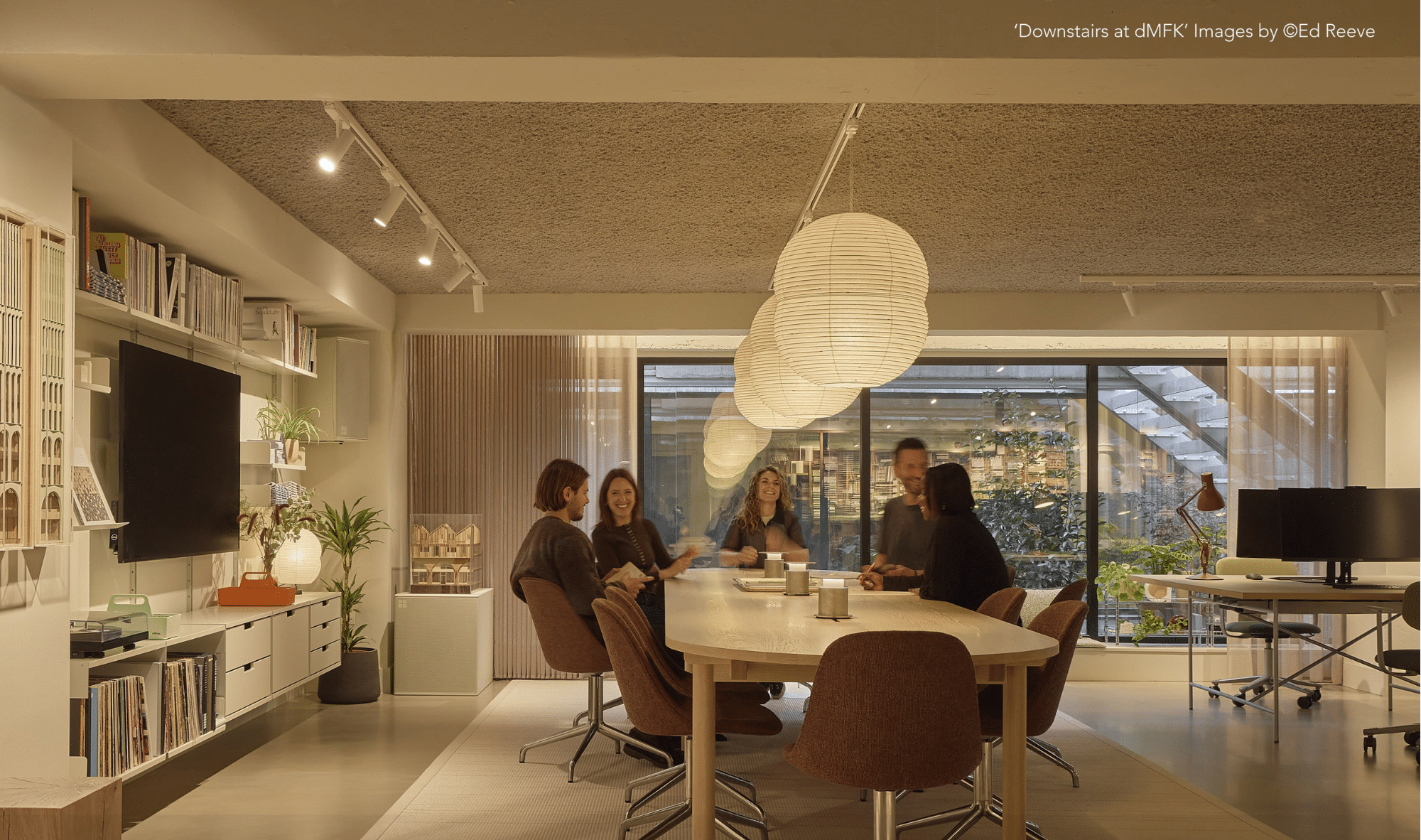 Modern open-plan office interior with shared desks and a warm, contemporary workspace design